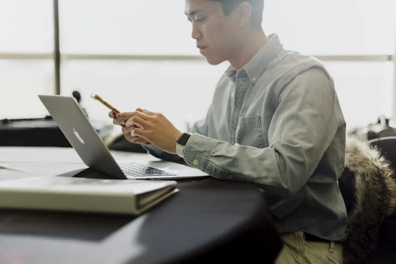 Professional reviewing documents on a laptop