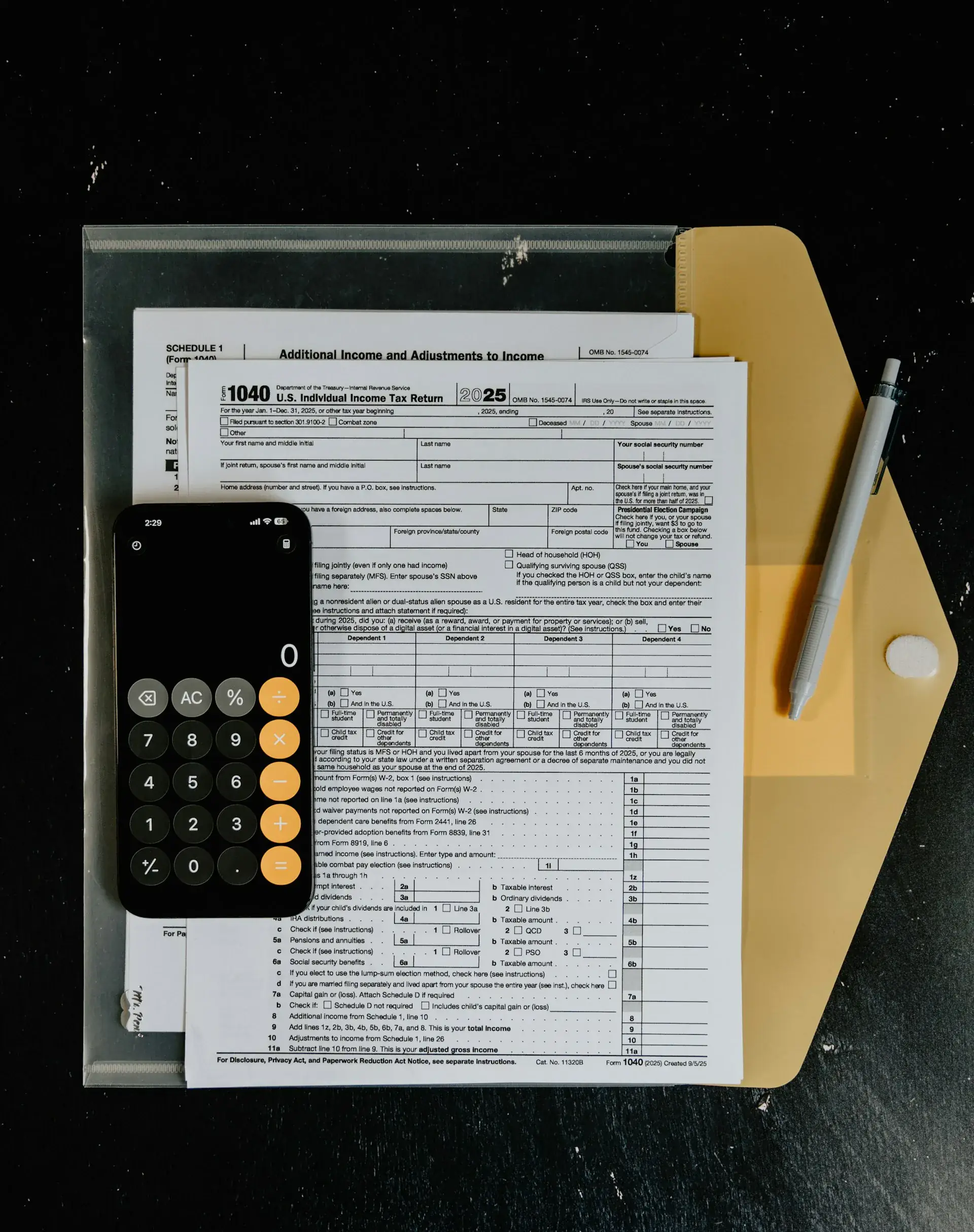 Tax forms with a calculator and pen on a desk